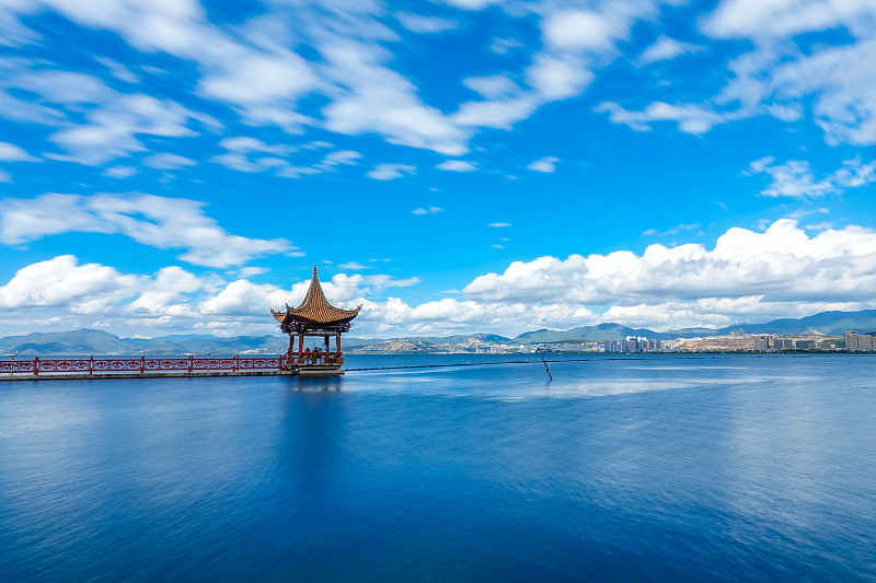 Haixin Pavilion on Erhai Lake, a red walkway reaching into the blue water