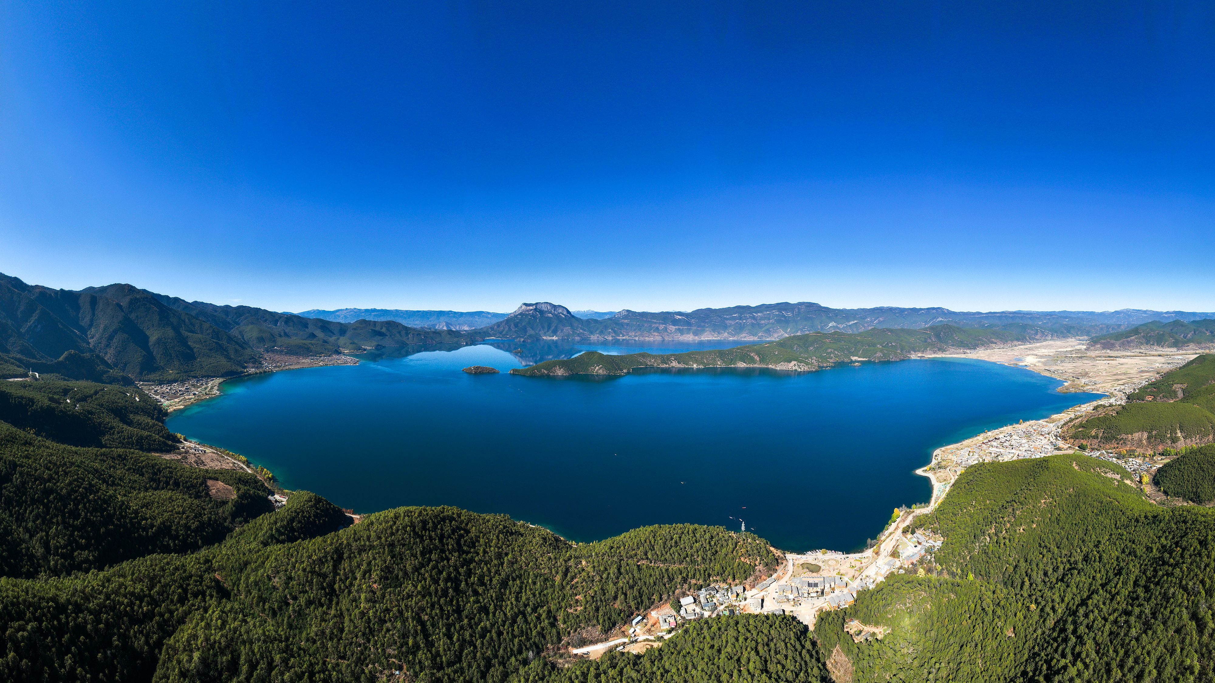 Aerial view of Lugu Lake, sapphire water cradled by green mountains